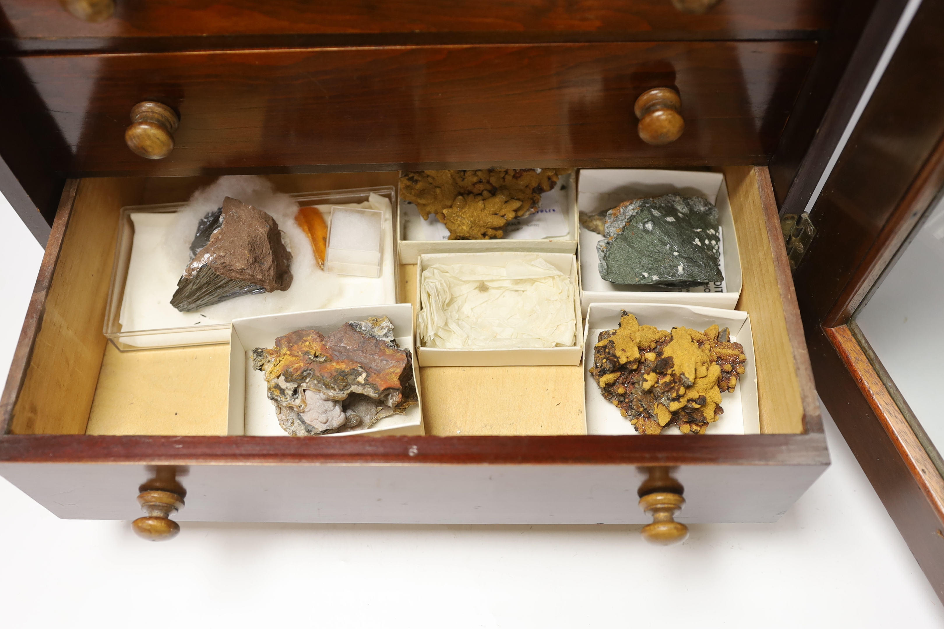An early twentieth century six drawer pine collector’s cabinet of mineral and crystal samples including; Amber and insects in amber, Baryteson Calcite, Aplite, Nodular Rhyolite, Desert Roses, etc. many specimens with lab